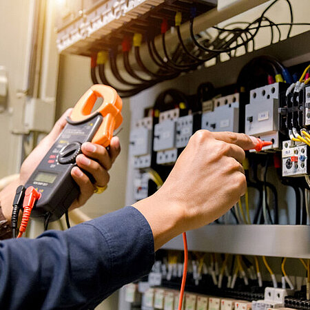 Mann überprüft Elektrotechnik zu Messung der Spannung und des Stroms